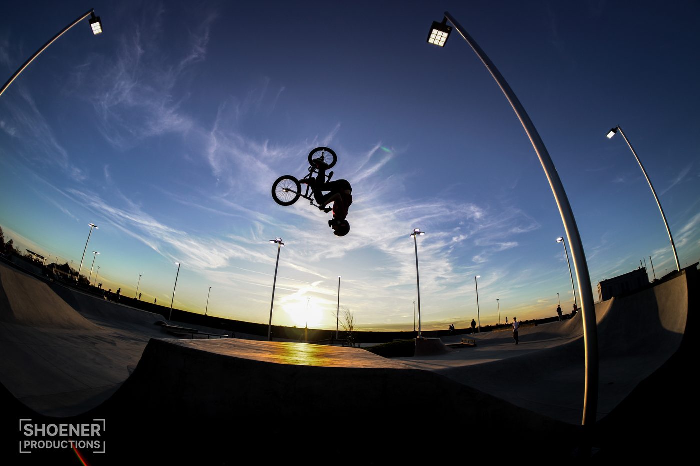 BMX rider mid-flip at sunset