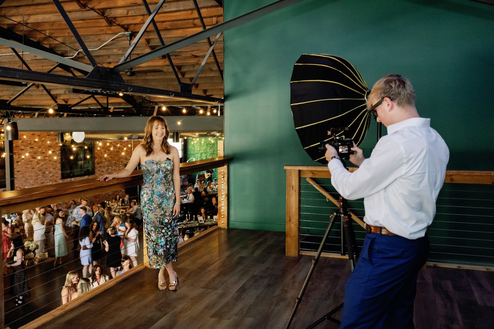 Isaac Shoener filming a woman at an event with a camera on a tripod and a large softbox light