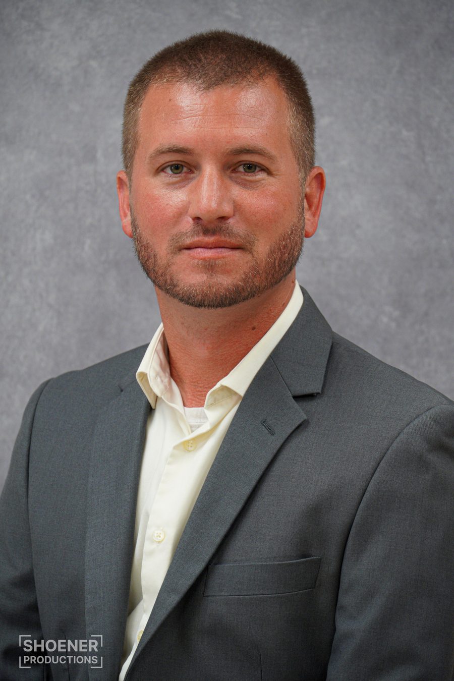 Professional headshot, man in gray suit